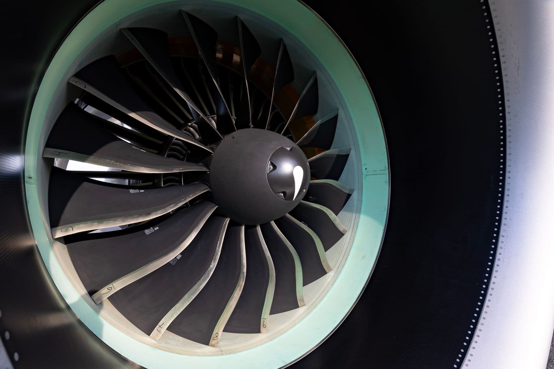 Front view of a gas turbine's rotor blades and central spinner inside its intake shroud